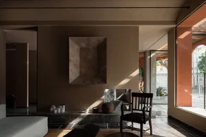 Contemporary living room with minimalistic design featuring concrete walls and furniture.