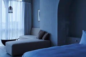 Modern minimalist bedroom featuring gray furniture and soft textiles.
