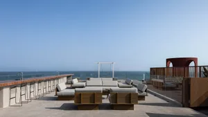 Contemporary rooftop bar with concrete flooring, bar stools, and seating areas
