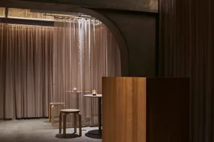 Industrial-style restaurant interior with fabric curtains.