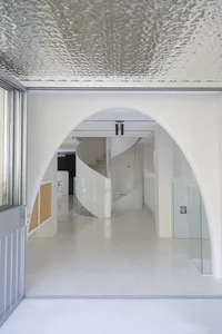 Minimalist corridor with concrete walls and glass railings.