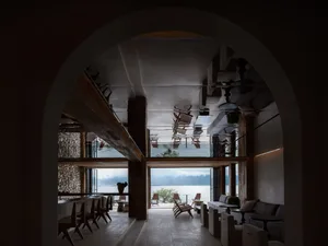 A modern bar lounge decorated with concrete walls and wooden furniture.