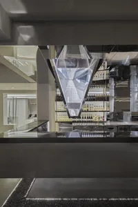 A modern bar with glass walls and reflections in a hospitality interior setting.