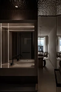 Modern bathroom featuring a concrete vanity with two sinks and a shower area with a frosted glass partition.