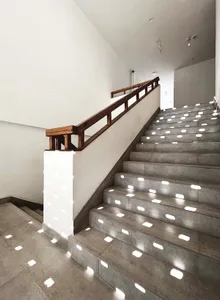 A modern industrial-style lobby with concrete stairs and flooring.