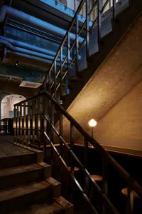 Concrete staircase with stainless steel railing in an industrial interior design setting.