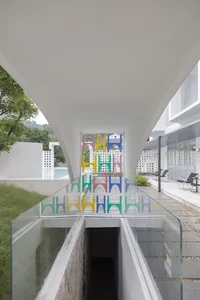 A modern glass interior space with colorful geometric shapes in the background.