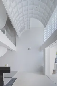 Minimalist interior with white concrete walls, glass walls, and metal elements.