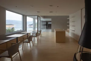 Modern living room with large windows, minimalist furniture, and natural wood accents.