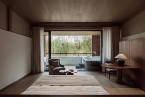 A modern residential bedroom featuring wood elements and a view of a garden.
