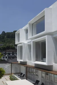 A modern residential house with a white exterior made of concrete.
