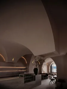 Interior design of a modern restaurant lobby with concrete walls and ambient lighting.