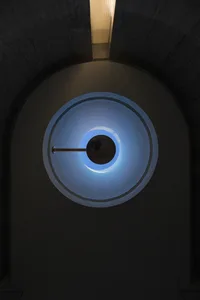 Circular glass ceiling light fixture with blue light and modern industrial design.