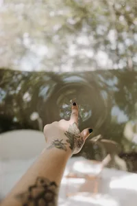 一隻帶有刺青的手掌輕觸玻璃表面。
