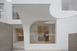 A modern interior space with a concrete structure and large windows.