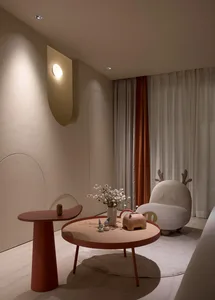 A modern living room featuring a rounded coffee table, a small side table, and a unique, plush armchair with antlers.