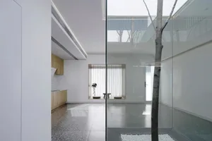 Modern minimalist living room with glass walls and concrete flooring