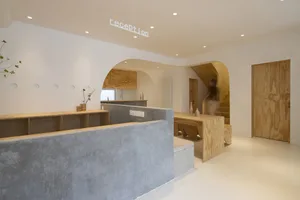 Modern reception desk with a concrete counter and wooden walls and cabinets.