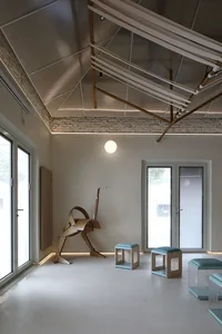 Minimalist room with wooden furniture and roof supports.