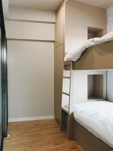 A minimalist bedroom featuring a wooden bunk bed.