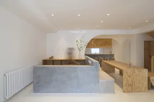 A minimalist coffee shop interior with wooden counters and seating.