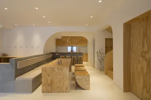 A minimalist living space featuring wooden furniture and neutral colors.