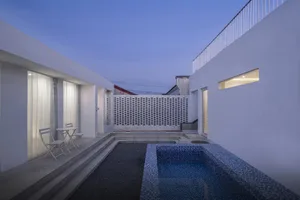 A contemporary patio with concrete floors, glass walls, and a pool.