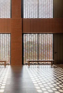 Modern corridor featuring brick and concrete tiles with unique lighting design.