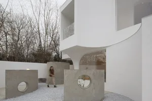 A modern exterior building with concrete elements, glass windows, and minimalist design.