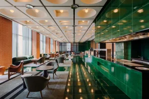 Modern hotel lobby with green-tile flooring and contemporary furniture.
