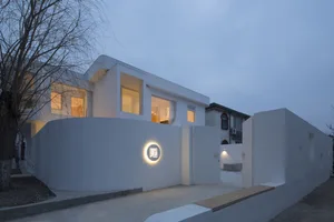 Modern home with a concrete exterior and warm indoor lighting during dusk