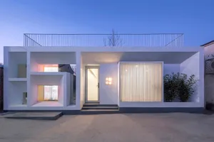 A modern minimalist house with a concrete exterior at dusk, featuring geometric shapes and clean lines.