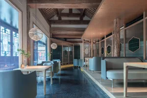 Contemporary seating and tables in a restaurant with modern design elements, including mixed materials and geometric shapes.
