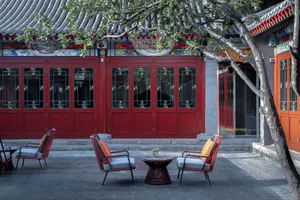 Outdoor seating area with red doors and traditional Chinese architecture