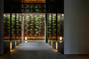 A minimalist modern corporate office entryway with glass walls and a concrete floor.