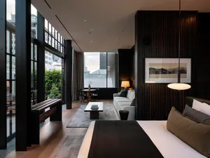Modern hotel room with black metal accents, glass windows, and minimalist decor.