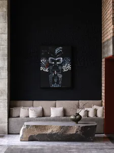A modern living room features a concrete coffee table, fabric seating, and a black wall art piece with a tribal design.
