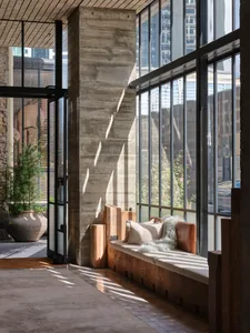 Modern lobby featuring a concrete column with glass windows, providing a minimalist and industrial aesthetic.