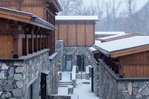 A snow-covered village with wooden and stone buildings.