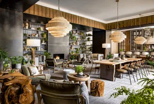Industrial style lobby with concrete and wooden accents, featuring a fireplace and bookshelves.
