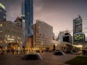 A modern cityscape featuring brick and glass buildings in an urban setting.