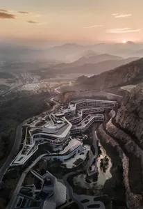 Modern resort building with concrete and glass structures on a mountainous landscape.