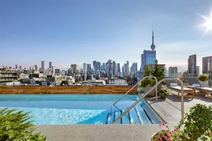 A rooftop pool overlooking a cityscape with modern buildings and skyscrapers.