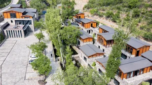 Aerial view of stone and timber residential houses nestled amidst greenery.