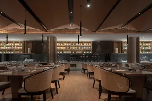 Modern industrial restaurant interior with wooden tables, concrete walls, and metal accents.