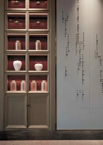 A modern interior design featuring wooden cabinets with glass doors displaying various knick-knacks and decorative objects, i