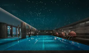 Modern indoor swimming pool with blue tiled walls and ceiling stars