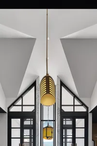 A modern interior with a metallic texture light fixture hanging from a ceiling.