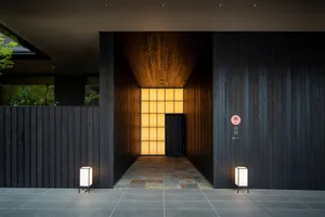 An entrance lobby with dark wooden walls and a glowing light fixture, set in a modern interior design style.