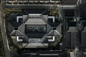 Aerial view of a building with tiled roofs and a landscaped courtyard.